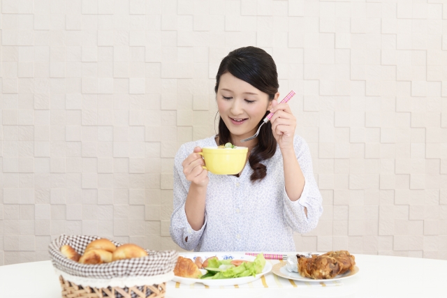 スープを食べる女性の画像