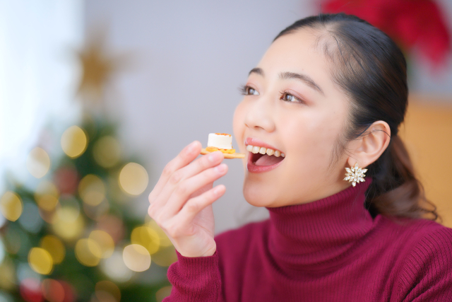 クラッカーを食べる女性の画像